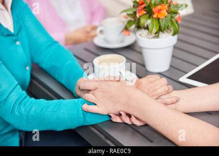 Krankenschwester oder Altenpflegerin hält die Hand eines älteren Bürgers zu den Komfort Stockfoto