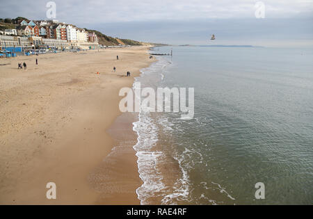 Leute Spaziergang entlang Boscombe Strand in Dorset. Stockfoto