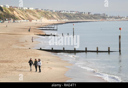 Leute Spaziergang entlang Boscombe Strand in Dorset. Stockfoto