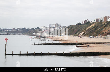 Leute Spaziergang entlang Boscombe Strand in Dorset. Stockfoto