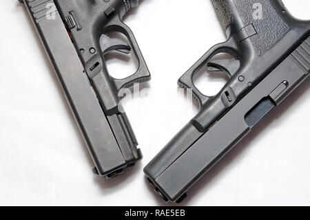 Zwei schwarze halbautomatische Pistolen, ein 9 mm und einen 40-Kaliber auf einem weißen Hintergrund, in der die verschiedenen Größen von Ihnen Stockfoto