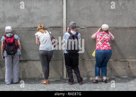 Berlin - Deutschland - Juni 2016: Besucher schauen, obwohl ein Teil der Berliner Mauer (Berliner Mauer) in der Bernauer Strasse. Stockfoto