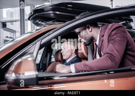 Wohlhabende reife reichen Mann in seiner neuen Pkw sitzen Stockfoto