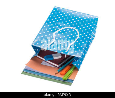 Schule Zubehör in einem blauen Polka Dot Geschenktasche liegen auf weißem Hintergrund Stockfoto