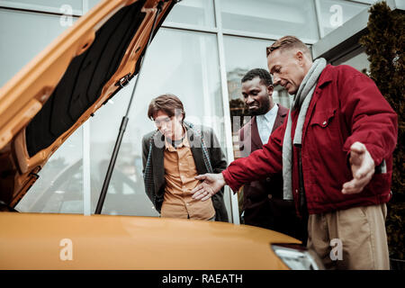 Junge dunkelhaarige Sohn Gefühl aufgeregt vor der Fahrt sein erstes Auto Stockfoto