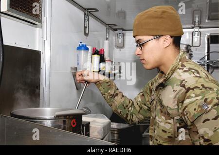 Us-Armee SPC. Ivan Cruz, eine kulinarische Spezialisten, auf die 2.BATAILLON zugeordnet, 2nd Brigade Combat Team, 325 Airborne Infanterie Regiment, kocht das Abendessen aus einer Kraft Anbieter Küche in der Nähe von Keramlais, Irak, Jan. 28, 2017. Kulinarische Spezialisten die Kraft Anbieter Küche Einheiten nutzen, um warme Mahlzeiten für die Soldaten, die Unterstützung von Combined Joint Forces Land Component Command-Betrieb inhärenten Lösen. CJTF-OIR ist die globale Koalition zu besiegen ISIS im Irak und in Syrien. Stockfoto