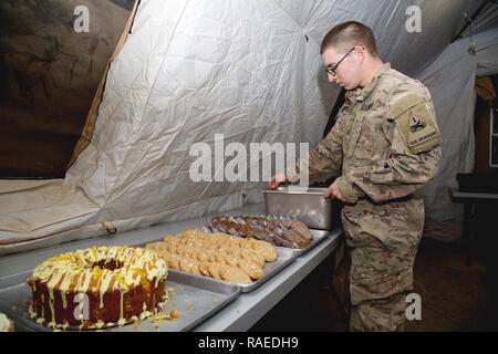 Us-Armee Pfc. Benjamin Britton, eine kulinarische Spezialisten, Bravo Batterie zugewiesen, 4.BATAILLON, 1 Field Artillery Regiment, 1st Armored Division, legt Desserts in der Vorbereitung für das Abendessen in der Nähe von Keramlais, Irak, Jan. 28, 2017. Kulinarische Spezialisten bereiten warme Mahlzeiten für die Soldaten, die Unterstützung von Combined Joint Forces Land Component Command-Betrieb inhärenten Lösen. CJTF-OIR ist die globale Koalition zu besiegen ISIS im Irak und in Syrien. Stockfoto