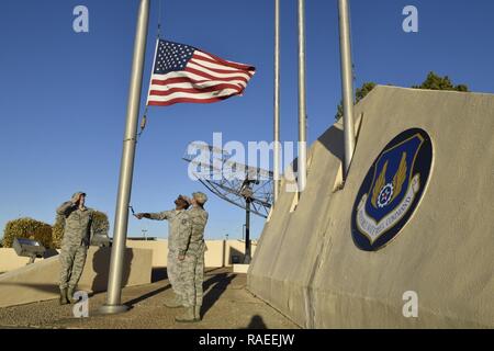 Militärische Mitglieder der Oklahoma City Air Logistics Komplexe senken Sie die amerikanische Flagge von der Basis flag Pole, während eines offiziellen Rückzug Zeremonie Jan. 24, 2017, Tinker Air Force Base, Oklahoma. OC-ALC durchgeführt die Exerzitien Zeremonie als Teil der offiziellen Tinker AFB 75-Jähriges Jubiläum Veranstaltungen. Tinker Hosts die Luftwaffe Sustainment Center und fällt unter das Air Force Materiel Command. Die AFMC Abzeichen auf der Wand wird angezeigt. Stockfoto