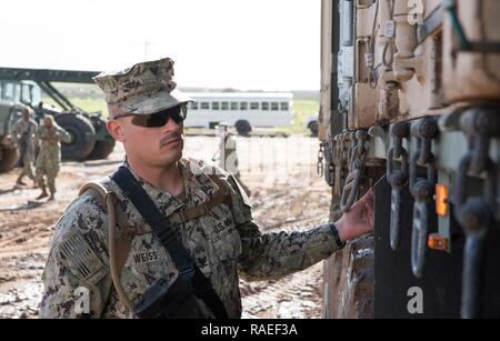 CAMP Pendleton, Calif (Jan. 24, 2017) - Equipment Operator 3. Klasse Peter Weiss, angeschlossen an die Amphibischen Bau Bataillon 1, sichert die Behälter, die auf ein Medium Tactical vehicle Austausch im Bereich Training (Ftx) 2017. FTX 2017 ist ein Szenario-basierte Übung entwickelt, Zug das Bataillon in Seabee bekämpfen Kriegsführung und zu testen. Stockfoto