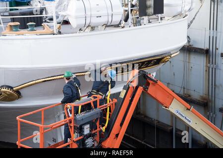 Mitglieder der Coast Guard Cutter Adler führen Sie Wartungsarbeiten für das Schiff trocken ist - für Reparaturen und Wartungsarbeiten an der Coast Guard Yard in Curtis Bay, Maryland, Jan. 26, 2017 angedockt. Das Patrouillenboot Eagle (WIX-327) ist eine 295-Fuß-barke Segelschiff verwendet Coast Guard Academy Kadetten zu trainieren, und lehrt sie, sowohl die historischen Aspekte des Segelns, sowie Themen wie Führung, Navigation und Teamarbeit. Der Adler wurde als Krieg Wiedergutmachung aus Deutschland im Jahr 1946 übernommen und an seinen aktuellen Homeport in New London, Connecticut. Us-Küstenwache Stockfoto