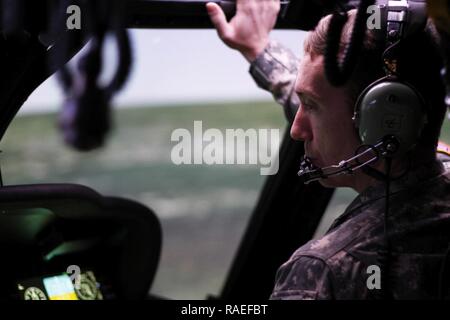 Warrant Officer 1 Mickey Argo, ein Iowa Army National Guard UH-60 Pilot mit Unternehmen C, 2. Brigade, 147 Aviation Battalion, Boone, Iowa, bereitet für einen "Flug" in der Black Hawk Fliegendes Personal Trainer, ein sehr intensives, home-station Flight Training Device für die UH-60 M, im Lager Dodge gemeinsame Manöver Training Center in der Johnston, Iowa. Das Argo war der erste Black Hawk Pilot auf dem BAT vor qualifiziert sind die UH-60M, eine modernisierte Version der UH-60 zu fliegen. Vor der Teilnahme an der UH-60 M Qualifikation Kurs, Argo verbrachten einige Tage im Camp Dodge Einführung in die a Stockfoto