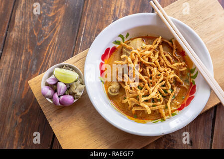 Curry Nudelsuppe (Khao soi) mit Hähnchenfleisch und würziger Kokosmilch auf Holz Tisch. Thailändische Küche nördlichen Stil in Chiang Mai. Stockfoto