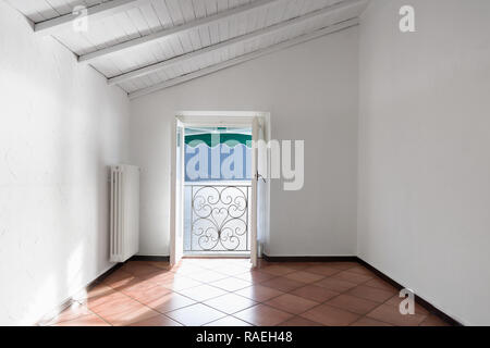 Leere Zimmer mit Blick auf den See an einem Frühlingstag. Geländer der Terrasse aus Schmiedeeisen. Stockfoto