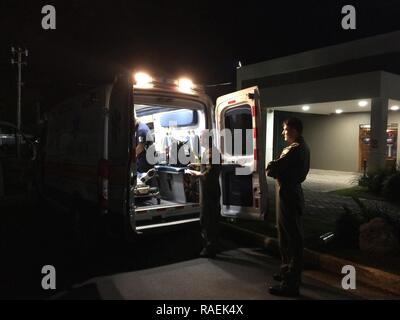 Coast Guard MH-65 Dolphin Helikopter crewmitglieder von Air Station Borinquen, einen Patienten zu Emergency Medical Service Personal bei der Fernando Luis Ribas Dominicci Flughafen in San Juan, Puerto Rico Dez. 12, 2018. Der Patient war Norwegischer Escape cruise ship Fluggast, der erfuhr, Schmerzen in der Brust und wurde vom Kreuzfahrtschiff medevaced von der Coast Guard helicopter Crew, ca. 60 Seemeilen nördlich von San Juan, Puerto Rico. Stockfoto