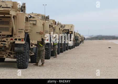 Soldaten mit der 504Th Military Intelligence Brigade prep ihre Fahrzeuge für Bahn Last, Dez. 12, 2018, Fort Hood, Texas. Sie hatten ihre Fahrzeuge von lokalen Zivilisten auf der Post kontrolliert, um sicherzustellen, dass die Fahrzeuge für die Bewegung sicher sind. Stockfoto