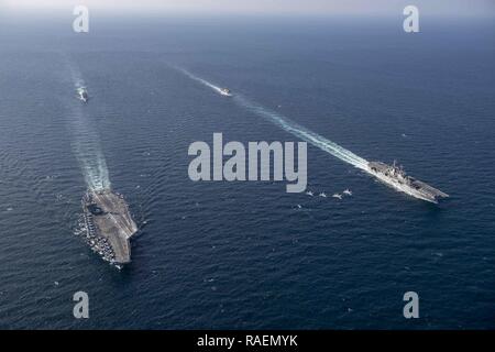 Us Navy F/A-18 Super Hornet und US Marine Corps B F-35 Lightning II Flugzeuge fliegen in Formation, wie der Flugzeugträger USS John C Stennis (CVN 74), den amphibischen Angriff Schiff USS Essex (LL 2), die geführte-missile Cruiser USS Mobile Bay (CG53) und die geführten Anti-raketen-Zerstörer USS Decatur (DDG73) Segeln in der Ausbildung im Arabischen Meer, Dez. 14, 2018. Die John C Stennis Carrier Strike Group, Essex Amphibious Ready Gruppe, und 13th Marine Expeditionary Unit sind die Durchführung von integrierten Maßnahmen im Arabischen Meer Stabilität und Sicherheit in der Region zu gewährleisten, Anschließen der Romantik Stockfoto