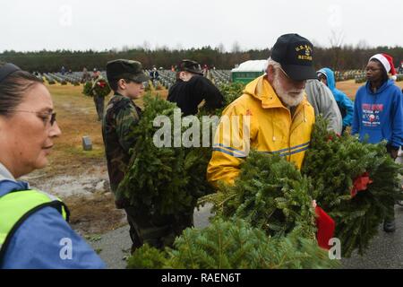 SUFFOLK, Virginia (31. 15, 2018) David Scott, ein pensionierter Navy chief quartmermaster, erhält Kränze von der Civil Air Patrol Freiwillige auf dem Friedhof der Albert G. Horton Jr.'s Memorial Veteran. Die Veranstaltung wird moderiert von der Horton Kranz Gesellschaft seit 11 Jahren gesunken Service Mitglieder zu ehren. Die mit Familie beigesetzt auf dem Friedhof sind die Chance, ihre ersten Kränze zu legen, die von den anderen Freiwilligen. Stockfoto