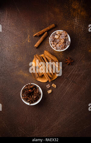 Zimtstangen, Sternanis Sprossen und karamellisierten Zucker auf einem dunklen Hintergrund. Blick von oben. Close-up. Stockfoto