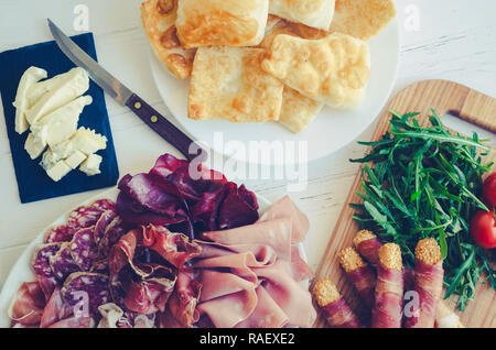 Traditionelle italienische Emilia Romagna, Bologna Region Vorspeise die Zubereitung von Pastasaucen fritte - gebratener Teig, Essen mit Gorgonzola Käse, verschiedene Fleisch- und Stockfoto