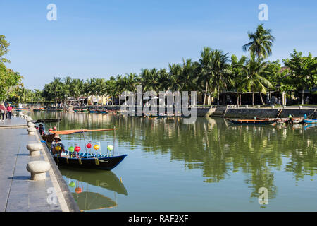 Traditionelle kleine Boote auf dem Thu Bon Fluss gesäumt von Palmen in der Altstadt der historischen Stadt. Hoi An, Quang Nam, Vietnam, Asien Stockfoto