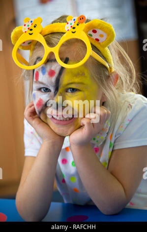 Ein kleines blondes Mädchen mit "Kinder im Brille benötigt" Stockfoto