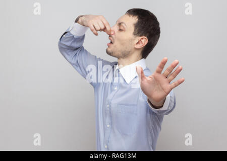 Gehen Sie von hier aus. Portrait von stattlichen Borste Geschäftsmann in klassischem Hellblau Shirt stehen seine Nase halten und mit stop Geste. indoor Stu Stockfoto