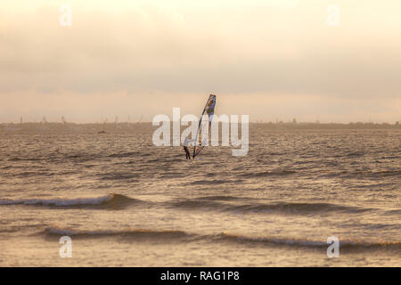 TALLINN, Estland - August, 10, 2017: sportman Windsurfer auf dem Meer gegen Sonnenuntergang orange sky Stockfoto