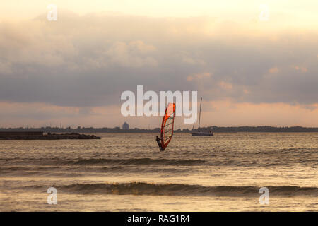 TALLINN, Estland - August, 10, 2017: sportman Windsurfer auf dem Meer gegen Sonnenuntergang orange sky Stockfoto