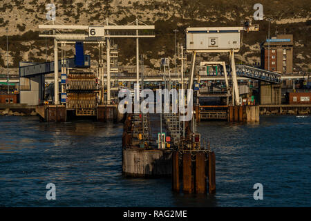 Fähren fahren in und aus dem geschäftigen Hafen - die Weihnachten weg ist in vollem Gange, als die Sonne über Dover steigt und die Fähren Überfahrt nach Calais. Stockfoto