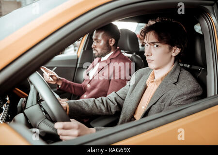 Dark-eyed junger Mann nervös, während zum ersten Mal fahren Stockfoto