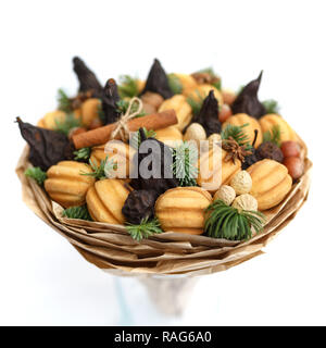 Original süßes Geschenk in Form von einem Blumenstrauß aus getrockneten Früchte, Kekse, Nüsse auf einem weißen Hintergrund. Close-up Stockfoto