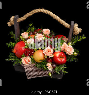 Einzigartiges Geschenk in Form von einer Holzkiste mit Blumen und Früchte auf einem schwarzen Hintergrund gefüllt Stockfoto