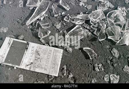 Glasscherben auf dem Bürgersteig neben einer beschädigten Abdeckung aus einer Streichholzschachtel. 1979 Stockfoto