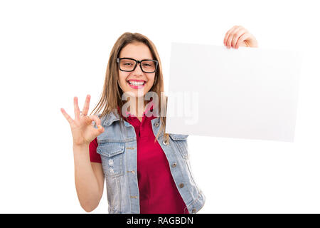 Modern casual Frau in Gläser Holding sauberes Papier leer und zeigt OK Zeichen an Kamera auf weißem Hintergrund Stockfoto