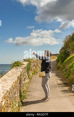 TENBY, Pembrokeshire, Wales - AUGUST 2018: die Person auf dem Küstenweg in Tenby, West Wales angehalten, etwas von Interesse. Stockfoto