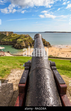 TENBY, Pembrokeshire, Wales - AUGUST 2018: Fass eines alten erhaltenen Kanone mit Blick auf die South Beach und St Catherin'es Insel in Tenby, West Wale Stockfoto