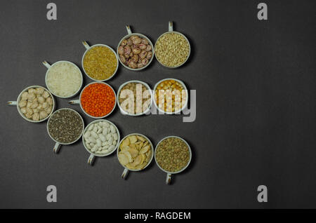 Vegan protein Quelle. Hülsenfrüchte - Linsen, Kichererbsen, Bohnen, interne Hülsen, Bulgur, Chia Samen auf schwarzem Hintergrund. Ansicht von oben kopieren. Stockfoto
