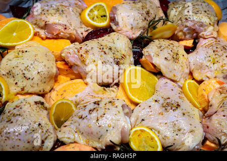 Raw würzige Hähnchenkeulen Oberschenkel bereit mit Süßkartoffel, Orangen und Rosmarin, Ansicht von oben zu backen Stockfoto
