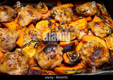 Ofen gebackenes Huhn Beine Oberschenkel mit Süßkartoffel, Orangen und Rosmarin, Ansicht von oben Stockfoto