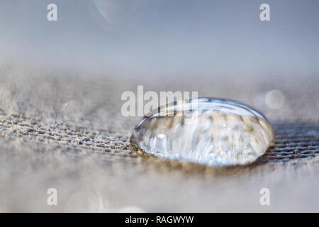 Ein Tropfen Wasser auf der Oberfläche des Gewebes. Makro anzeigen. Wählen Sie Stockfoto