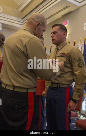 Kommandant des Marine Corps Gen. Robert B. Neller, Links, Stifte ein Navy und Marine Corps Commendation Medal auf Staff Sgt. Johnathan D Charles während der Kombinierten Preisverleihung im Marine Corps Base Quantico, Dreieck, Va., Nov. 8, 2017. Charles war das zweite Marine bekämpfen Ausbilder des Jahres für 2016. Stockfoto