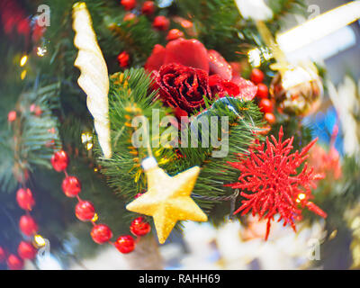 Hell und hübsch dekoriert mit Spielzeug Weihnachtsbaum gegen glänzend beleuchteten Soft konzentrierte Hintergrund. Weihnachten und Neujahr Konzept. Stockfoto