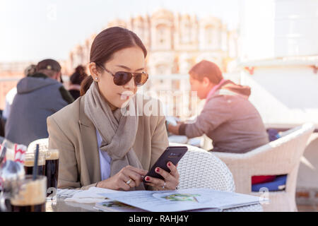 Business Frau mit Sonnenbrille auf dem Mobiltelefon in den Händen der Suche Stockfoto