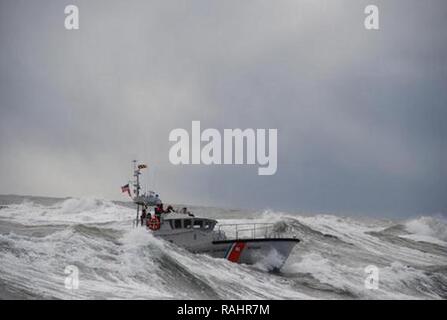 Der Küstenwache Sektor Columbia River Operations Specialist reagiert auf eine mayday Anruf vom Kapitän des Fischereifahrzeugs Küsten Herrschaft nach dem Schiff, auf dem Wasser an der Mündung des Columbia River, Feb 5, 2017. Küstenwache boot Besatzung gerettet Die drei Fischer, die von und unterstützt Sie darin, Entwässerung, deren Schiff und schleppen Sie in Sicherheit. Stockfoto