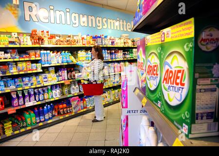 Frau auf der Suche nach Reinigungsmittel in einem Korridor mit Haushaltswaren beim Einkaufen in einem Self-service-Lebensmittelabteilung Stockfoto