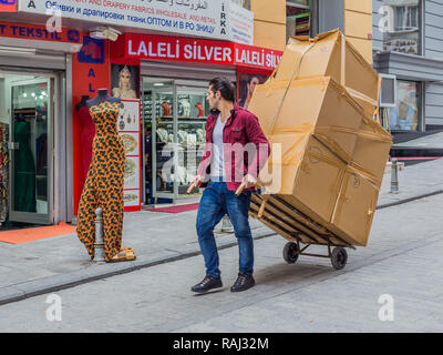 Istanbul, Türkei, 24. Februar 2015: Mann ziehen Boxen auf einem Trolley, unten eine Straße in Laleli. Stockfoto