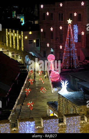 Fußgänger laufen entlang einer weihnachtlich geschmückten Bab el Gadid Straße, die zum Neuen Tor in der Altstadt des Christlichen Viertels Ost-Jerusalem Israel führt Stockfoto