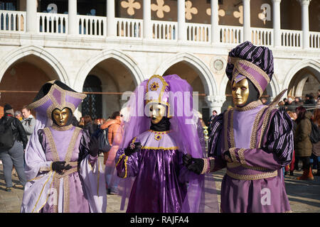 Venedig, Italien - 10. Februar 2018: Die Menschen in den goldenen Masken und Kostüme auf dem Markusplatz (Piazza San Marco) im Karneval von Venedig Stockfoto