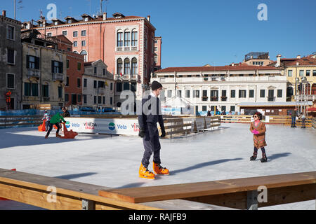 Venedig, Italien - 10. Februar 2018: Kinder mit Eltern Spaß auf der Eislaufbahn Stockfoto