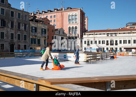 Venedig, Italien - 10. Februar 2018: Kinder mit Eltern Spaß auf der Eislaufbahn Stockfoto